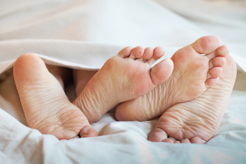 bare feet in the bed - image courtesy of Shutterstock