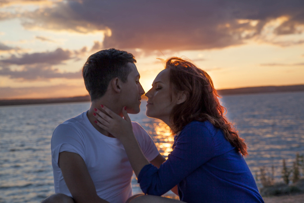Image of couple kissing at sunset courtesy of Shutterstock