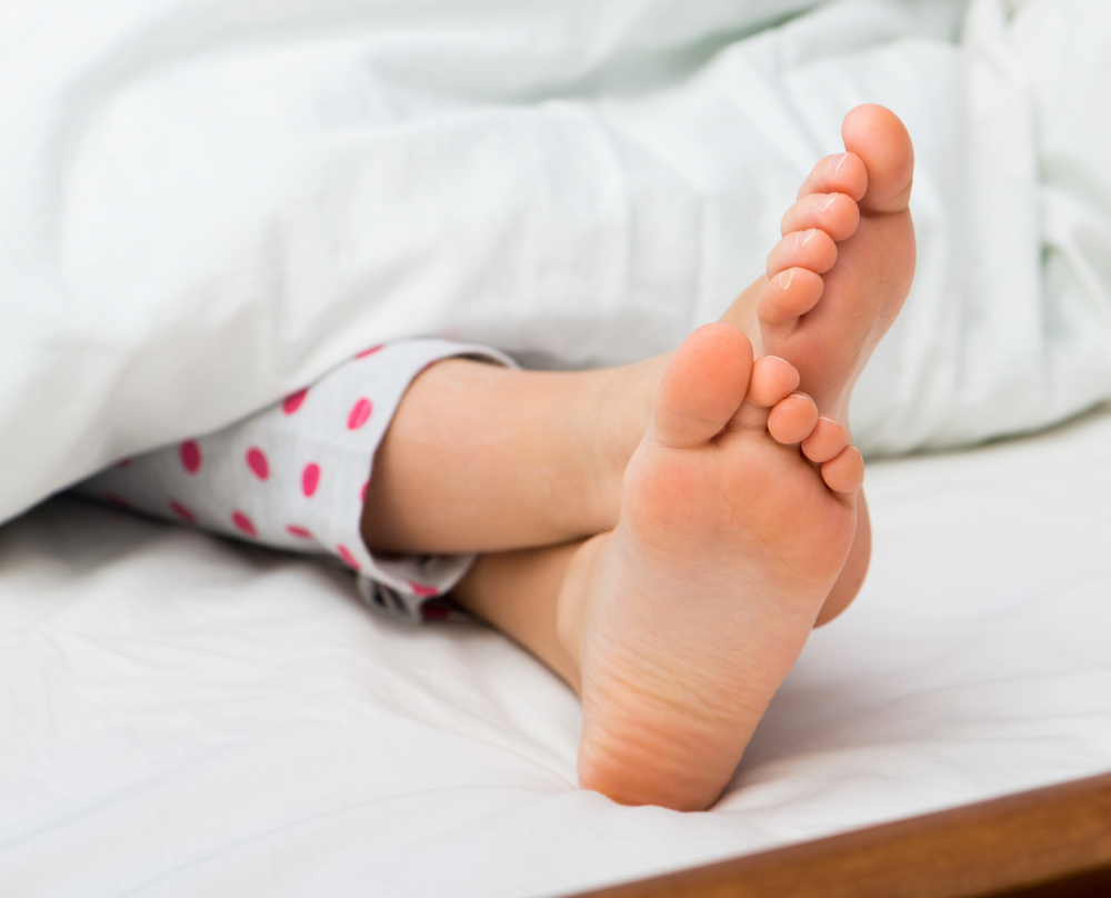 Sleeping feet under duvet - image courtesy of Shutterstock