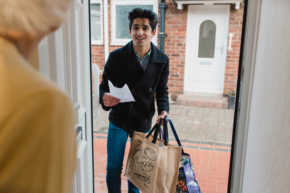 Teenager delivering groceries to elderly neighbour